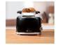 Schwarzer Toaster mit Brötchen auf einem Brötchenaufsatz, auf einer Holzplatte, mit der Aufschrift „1973“.