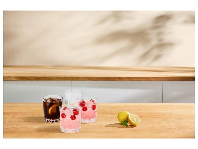 Erfrischende Getränke mit Himbeeren und Zitronen auf einer Holztheke.