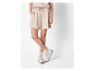 Beige Shorts und weiße Plateausneaker.