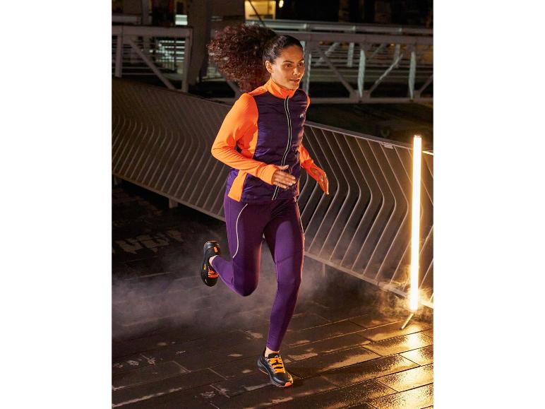 Frau in lila Laufkleidung und schwarzen Laufschuhen beim Laufen in der Nacht.