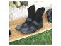 Schwarze Neoprenstiefel mit Klettverschluss auf einem Surfbrett und Gras.
