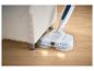 Silvercrest Akku-Bodenwischer reinigt unter einem hellen Sofa auf Holzboden.