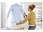 Eine Frau verwendet einen Cleanmaxx Dampfglätter, um ein Hemd zu glätten.