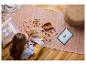 Kind baut LEGO-Set auf dem Boden mit einem Tablet, das Anleitungen zeigt.