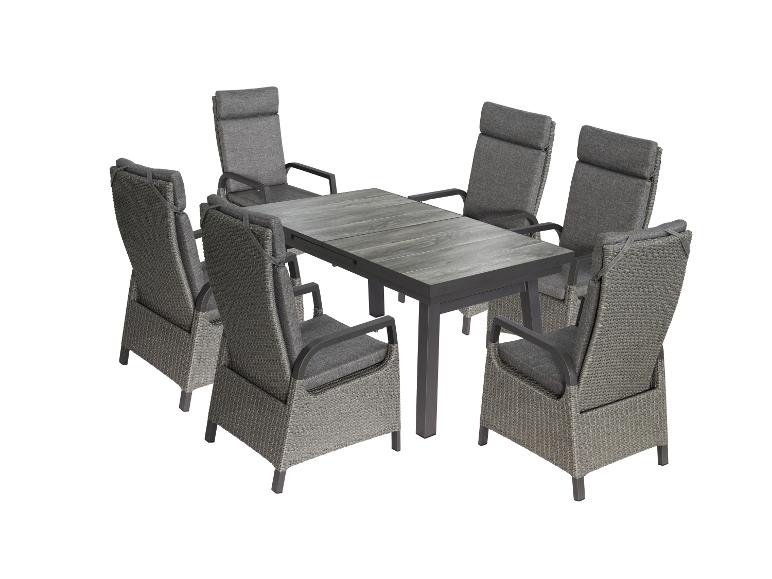 Essgruppe im Freien: Tisch und sechs graue  Geflechtstühle.