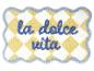 Gelb-weiß karierte Badematte mit blauem „la dolce vita“-Schriftzug.