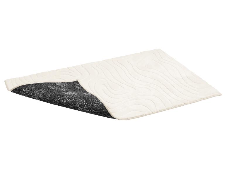 Cremefarbene Badematte mit Wellenmuster und rutschfester Unterseite mit Blumenmotiv.