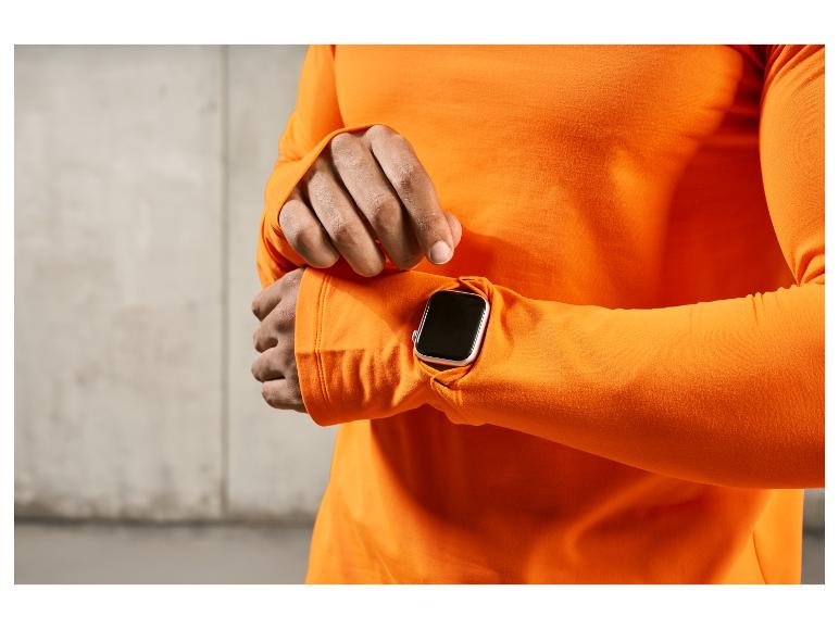 Ein Mann trägt ein orangefarbenes Shirt und eine Apple Watch.