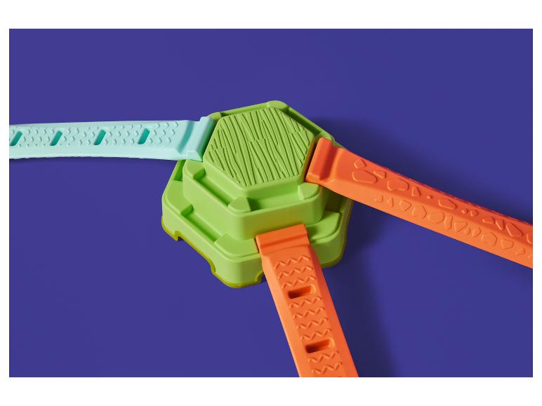 Konstruktionsspielzeug mit grünem Sockel und drei farbigen Bändern: Türkis und zwei Orange.