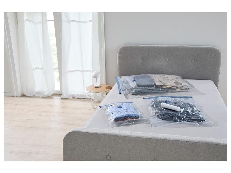 Vakuumbeutel zur Kleideraufbewahrung auf einem Bett, mit Pumpe.
