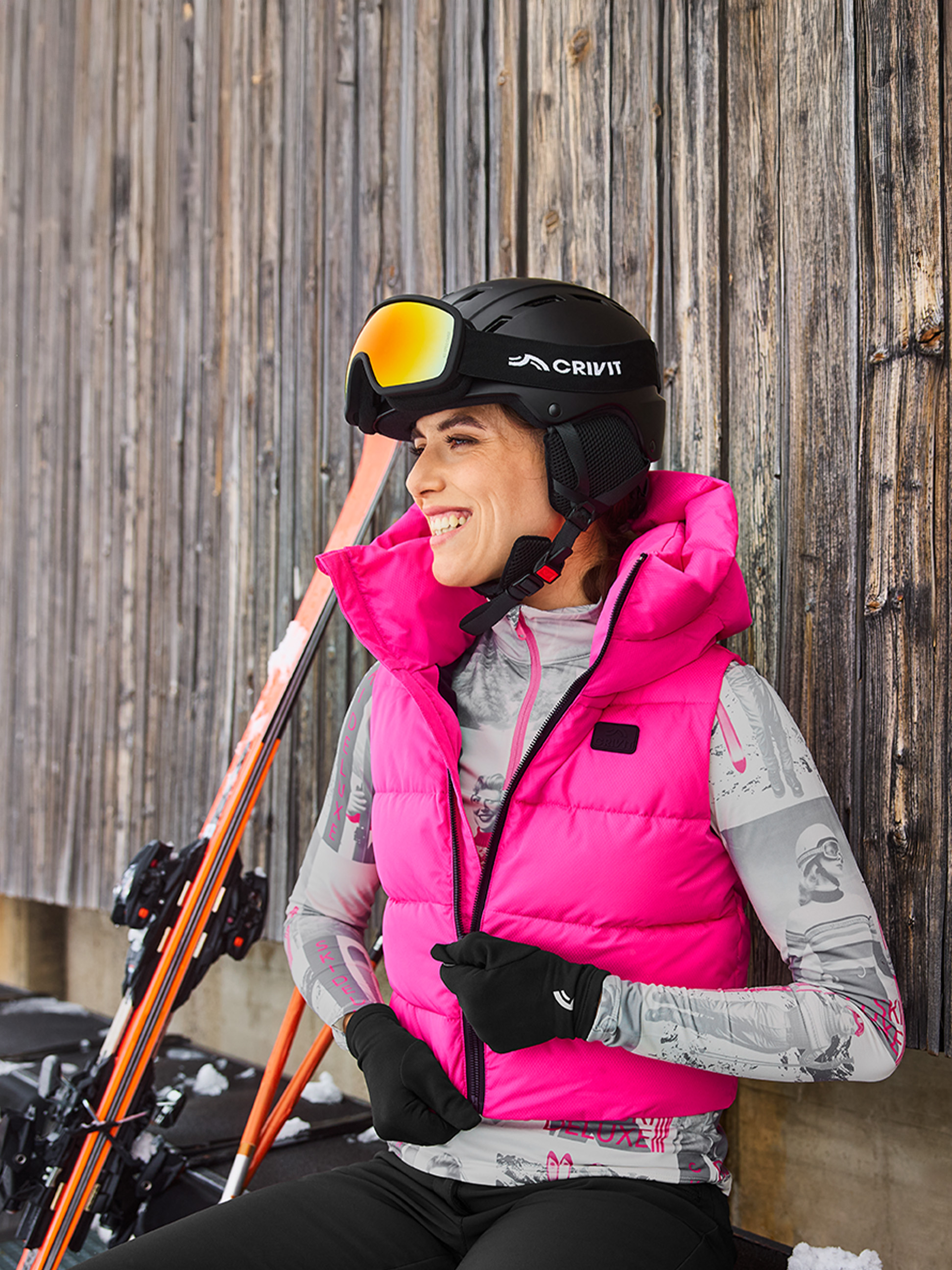 Frau in pinker Skijacke und Crivit Helm mit Brille, lächelnd.