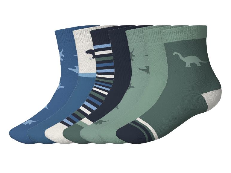 Set aus 6 Paar Kindersocken mit Dinosaurier-Motiven in Blau- und Grüntönen.