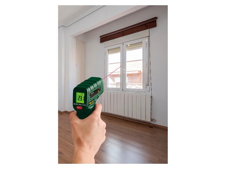 Eine Hand hält ein Parkside Infrarot-Thermometer und misst die Temperatur eines Fensters.