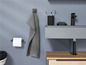 Badzubehör mit Handtuchhaken, Toilettenpapierhalter und Waschbecken.