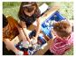 Kinder spielen mit kinetischem Sand an einem Holzsandy-Tisch.
