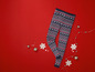 Ein Paar blaue Leggings mit einem Weihnachtsmuster auf rotem Hintergrund