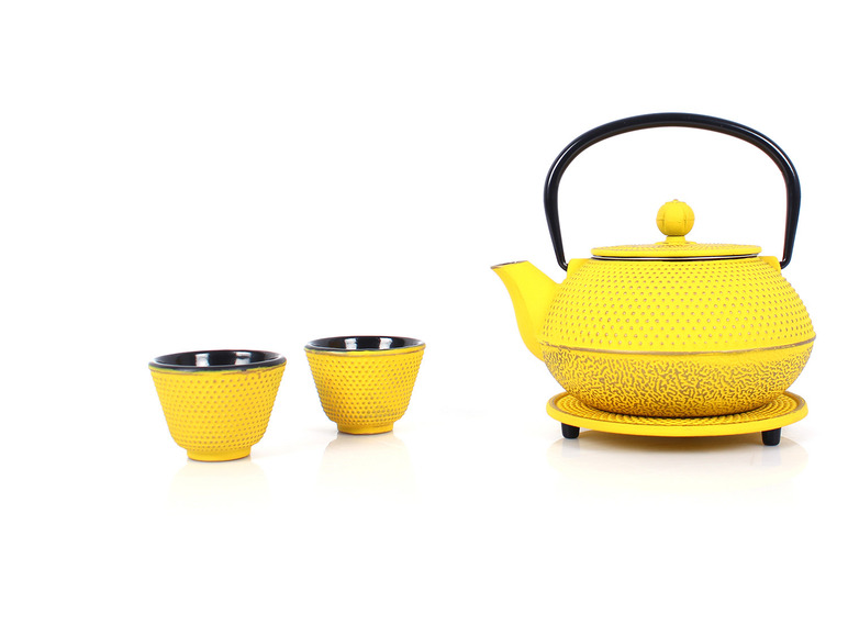 Gelber Teekanne und zwei Teetassen.