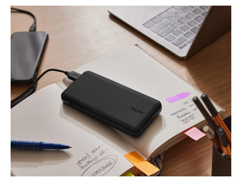 Tronic Powerbank, Smartphone und Laptop auf einem Schreibtisch.