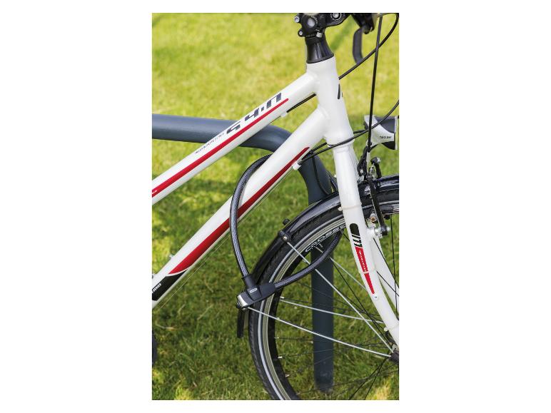 Weißes Fahrrad mit roten Akzenten, mit einem schwarzen Kabelschloss an einem Fahrradständer befestigt.