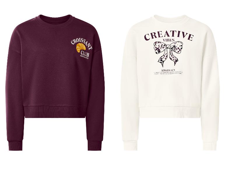 Zwei Sweatshirts: ein bordeauxrotes mit „Croissant Club“ und ein weißes mit „Creative Vibes“.