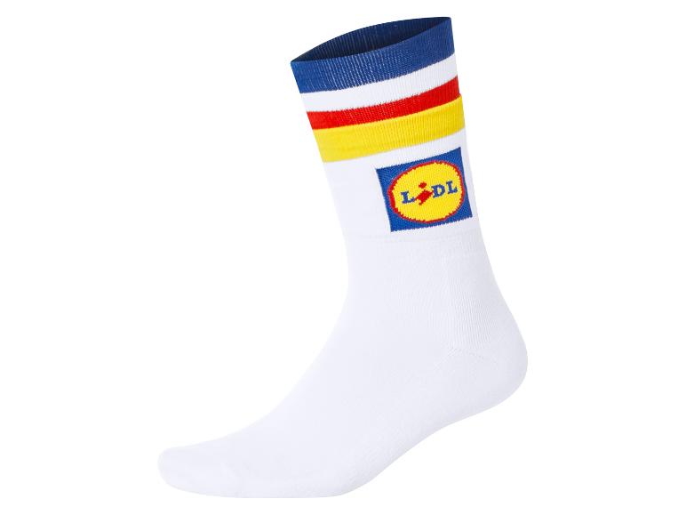 Weiße Socke mit blauen, roten und gelben Streifen, mit einem runden Logo.