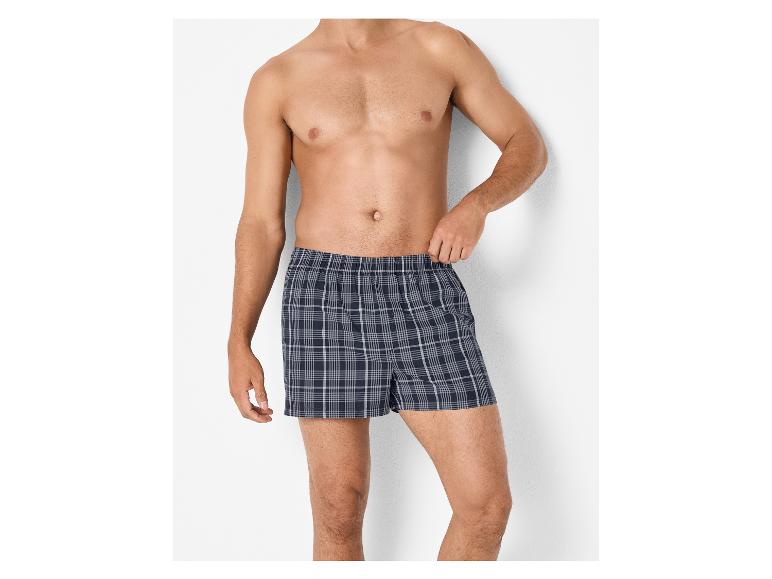 Mann in dunkelblauen karierten Boxershorts.