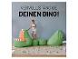 Ein grüner Dinosaurier-förmiger Sitzsack mit Bällen und einem Kind, das darauf klettert.