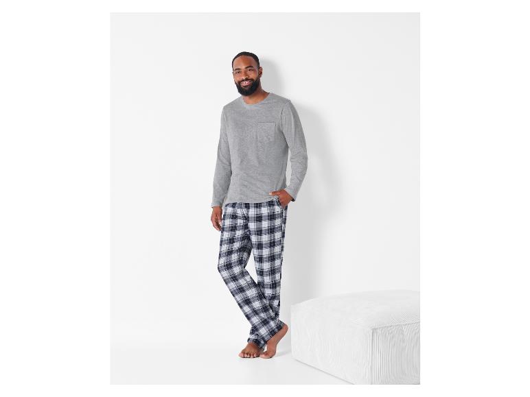 Mann in grauem Langarmshirt und karierter Pyjamahose.