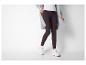 Frau in grauem Strickcardigan, weißem Top und dunklen Leggings mit Sneakern.