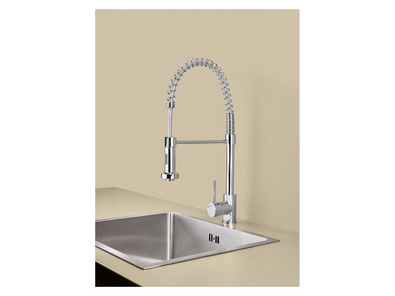 Verchromter Küchenhahn mit Spiralfeder und Edelstahlspüle in beiger Arbeitsplatte.