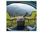 Tragbare Kühlbox mit Getränken und zwei Campingstühlen vor einer Berglandschaft.