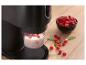 Schwarzes Küchengerät mit Himbeeren und Milch, auf einer Holzoberfläche.