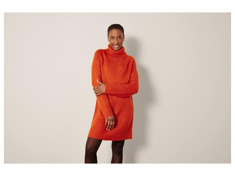 Eine Frau in einem orangefarbenen Strickkleid.