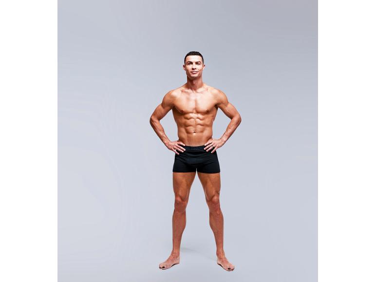 Mann in schwarzen Boxershorts, zeigt athletische Figur.