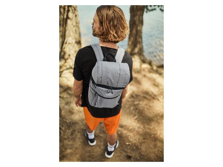 Mann mit grauen Crivit Rucksack an einem See.