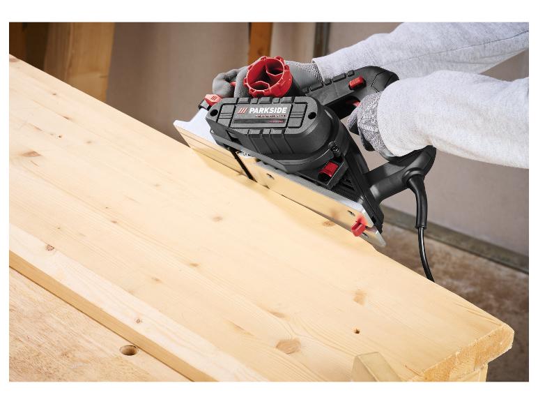 Person benutzt eine Tauchsäge, um ein Holzbrett auf einer Werkbank zu schneiden.