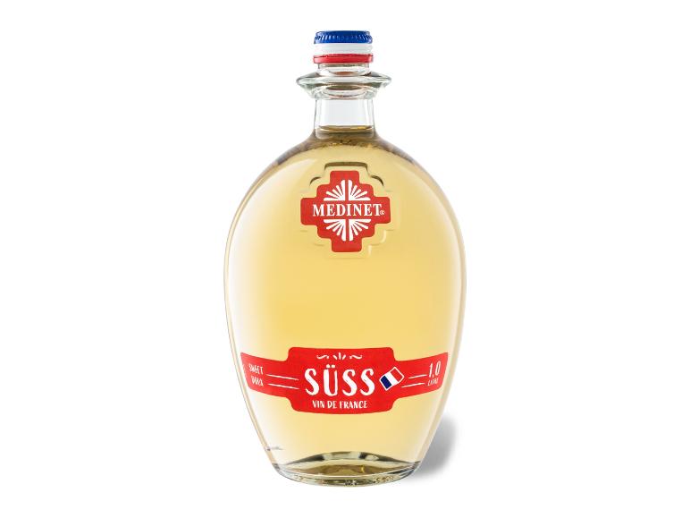 Eine Flasche Medinet Süss Weißwein mit rotem Etikett und dreifarbigem Verschluss.