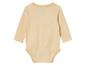 Ein hellbeiger Baby-Body mit langen Ärmeln.