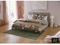Schlafzimmer mit Doppelbett, floraler und gestreifter Bettwäsche und grünem Teppich.