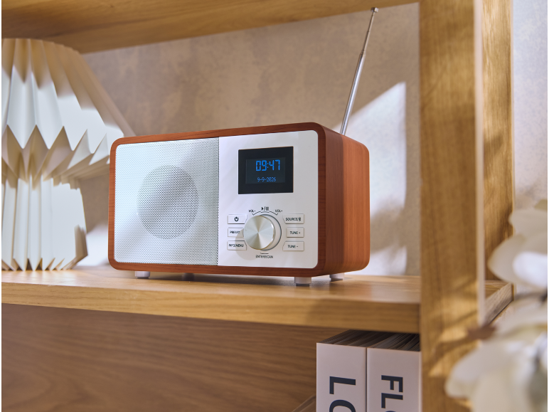 Holzradio im Retro-Stil auf einem Regal mit Uhrzeit auf dem Display.
