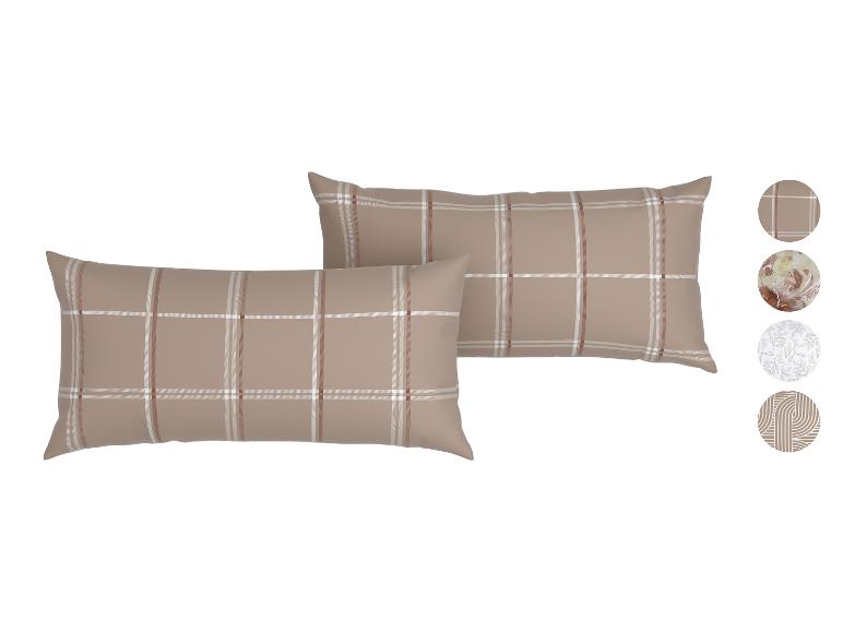 Zwei karierte Kissen in Beige, Weiß und Braun, mit Stoffmustern.