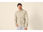 Ein Mann in einer hellgrünen Fleece-Hemdjacke und einer schwarzen Mütze.