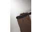 Braune Hose mit schwarzem Gürtel auf hellgrauem Hintergrund.