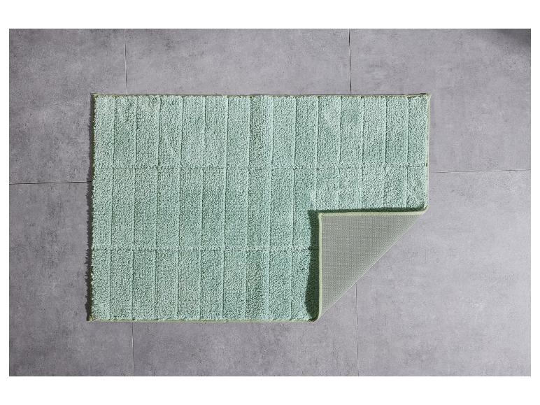 Texturierte, pastellgrüne Badezimmermatte.
