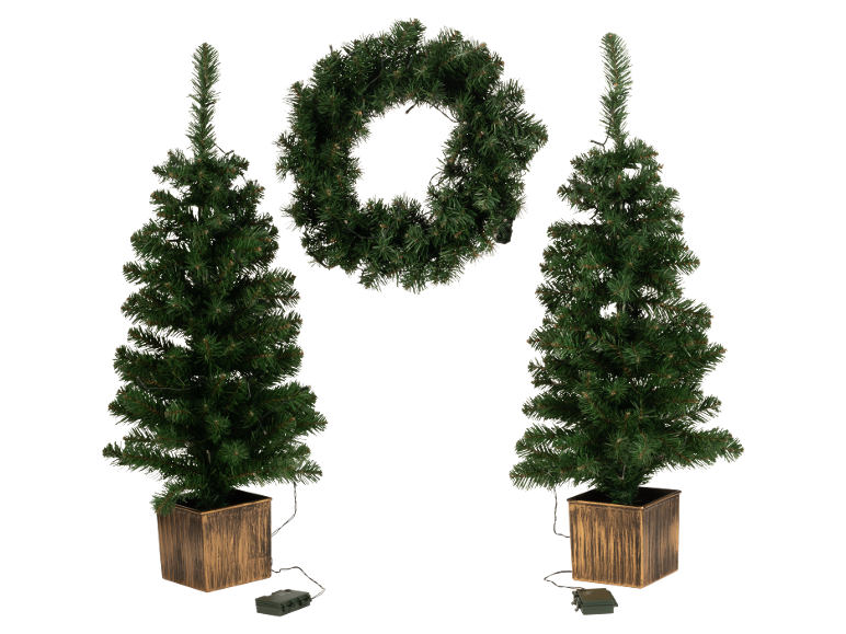 Zwei künstliche Weihnachtsbäume in Töpfen und ein Weihnachtskranz, alle beleuchtet.