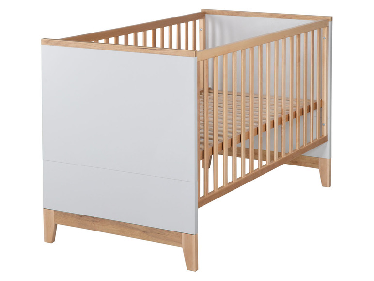 Ein Babybett aus Holz mit weißen Seitenpaneelen.
