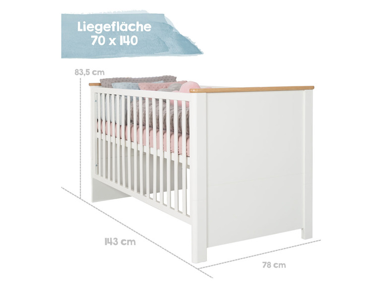 Weißes Babybett mit Holzdetails und rosa Bettwäsche.