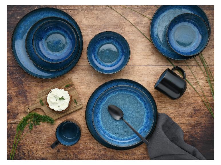 Blaue Teller und Tassen auf einem Holztisch