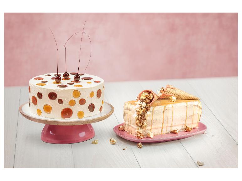 Zwei dekorierte Kuchen, einer mit Karamellpunkten und Kirschen, der andere mit Popcorn und Glasur.