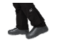 Schwarze Hose mit weißem Logo und schwarze Schuhe mit grauer Sohle.